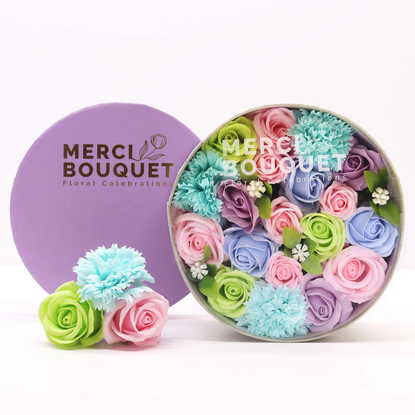A round gift box full of blue, green, pink and purple soap flowers. Roses. The petals are made of soap.