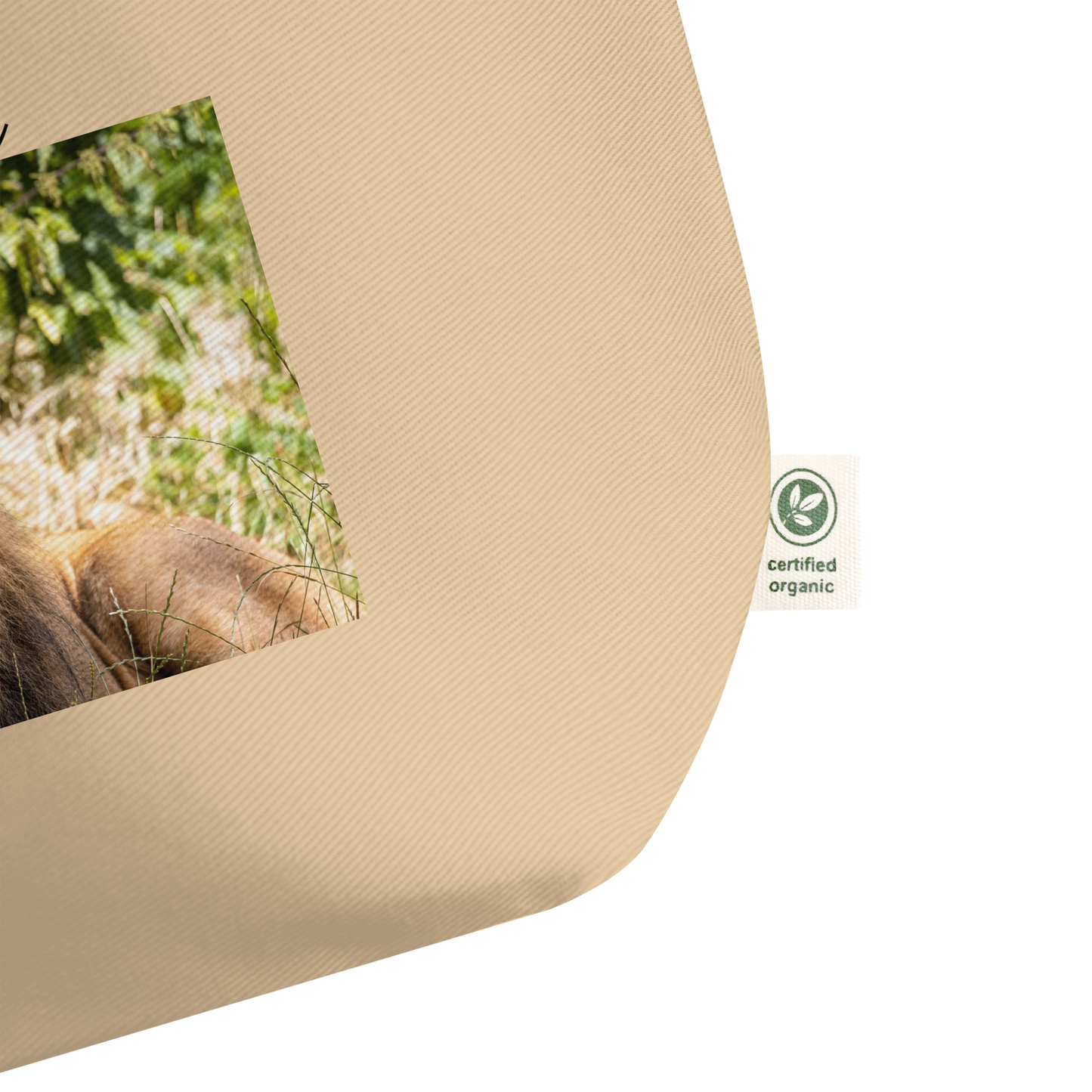 Beige tote bag with a certified organic cotton label and blurred natural background