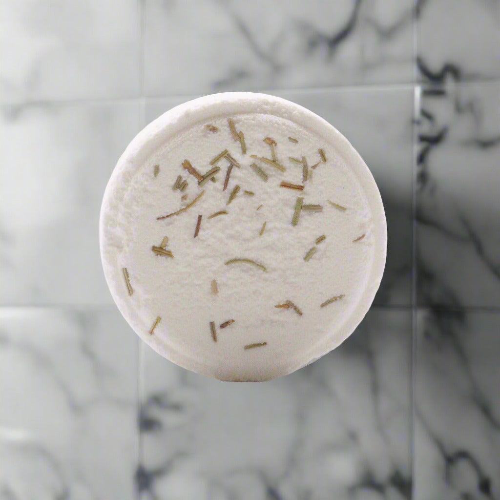 One Mood Boost shower steamer with essential oils. On a marble countertop in a bathroom.