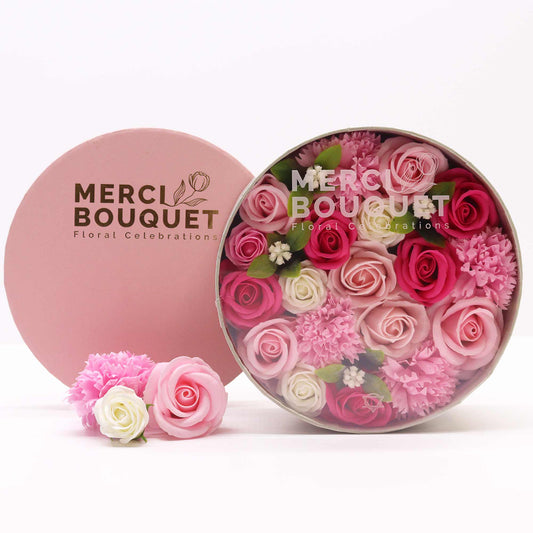 A round gift box full of pink, red and white soap flowers. Roses. The petals are made of soap.