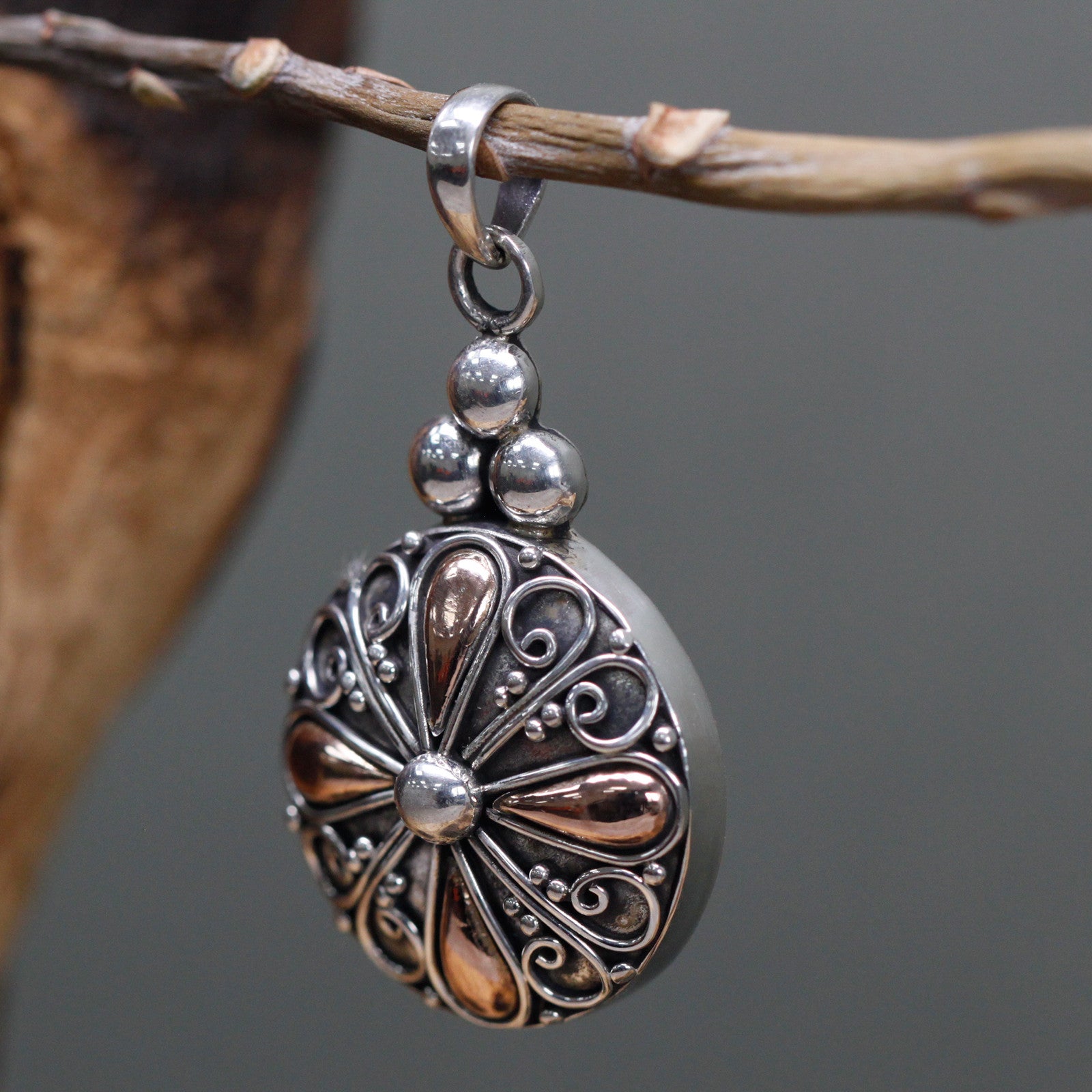 Jewellery for women. A round pendant handmade by artisan families. Made from Sterling silver and gold.