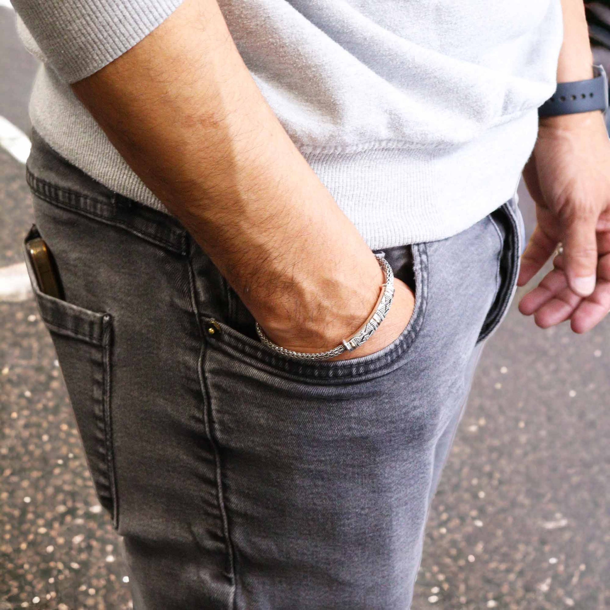 A man wearing a single chain bracelet on his wrist. Jewellery for men and women. Sterling silver and gold.