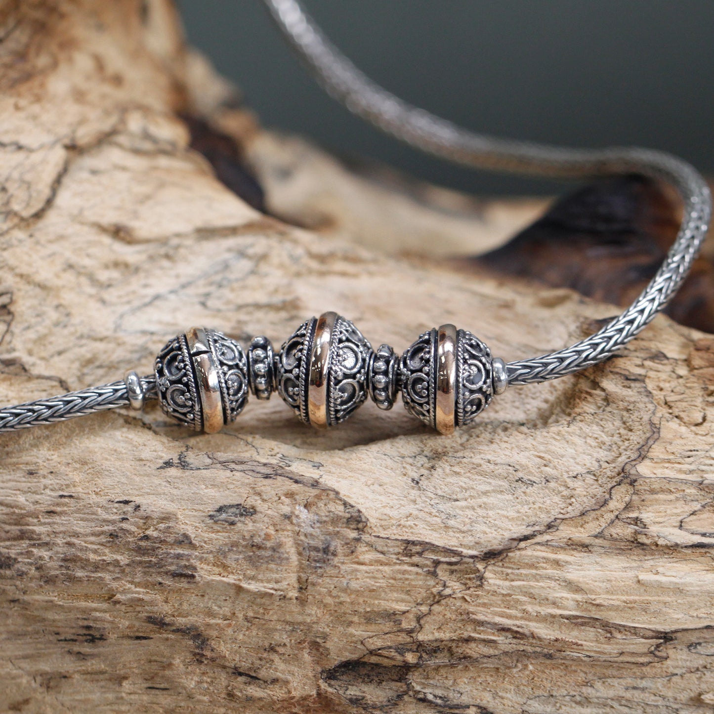 A close up view of the middle part of the women's traditional Oriental style necklace. Sterling silver and 18K gold.