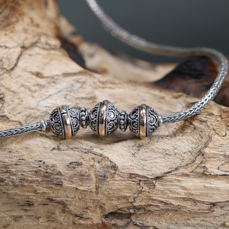 A close up view of the middle part of the women's traditional Oriental style necklace. Sterling silver and 18K gold.