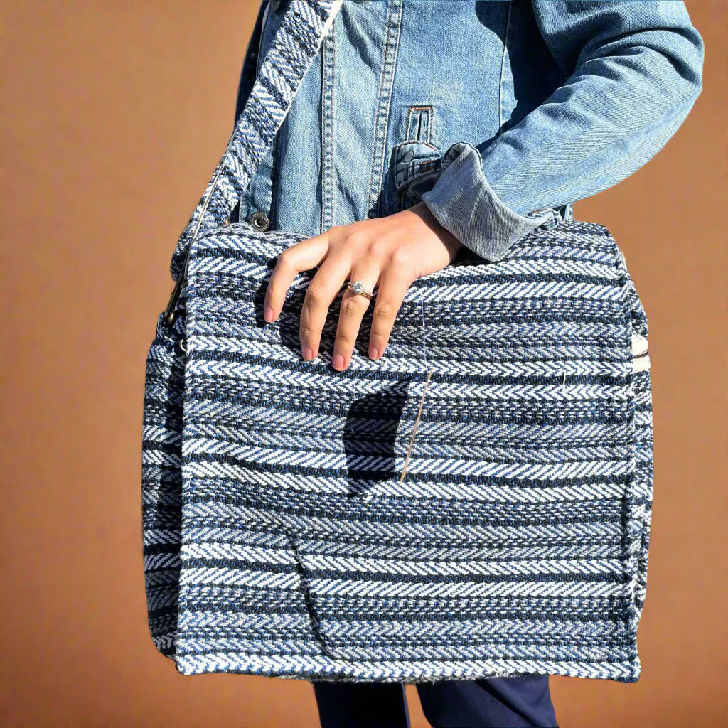 Woman carrying a quality laptop bag. Handmade. Cotton. Blue and grey stripes.