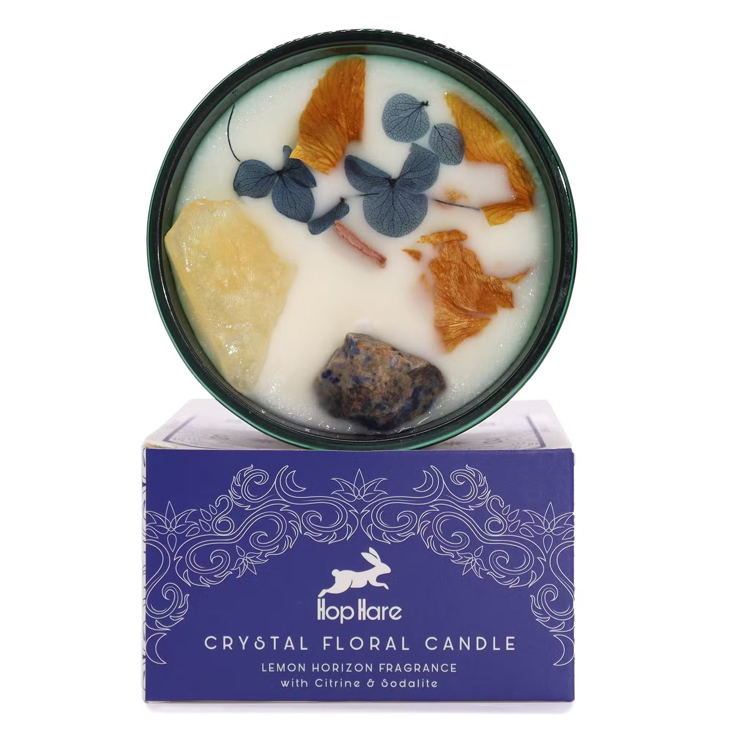 'The Sun' soy candle with crystals and dried flowers. In a glass jar. On top of a gift box.