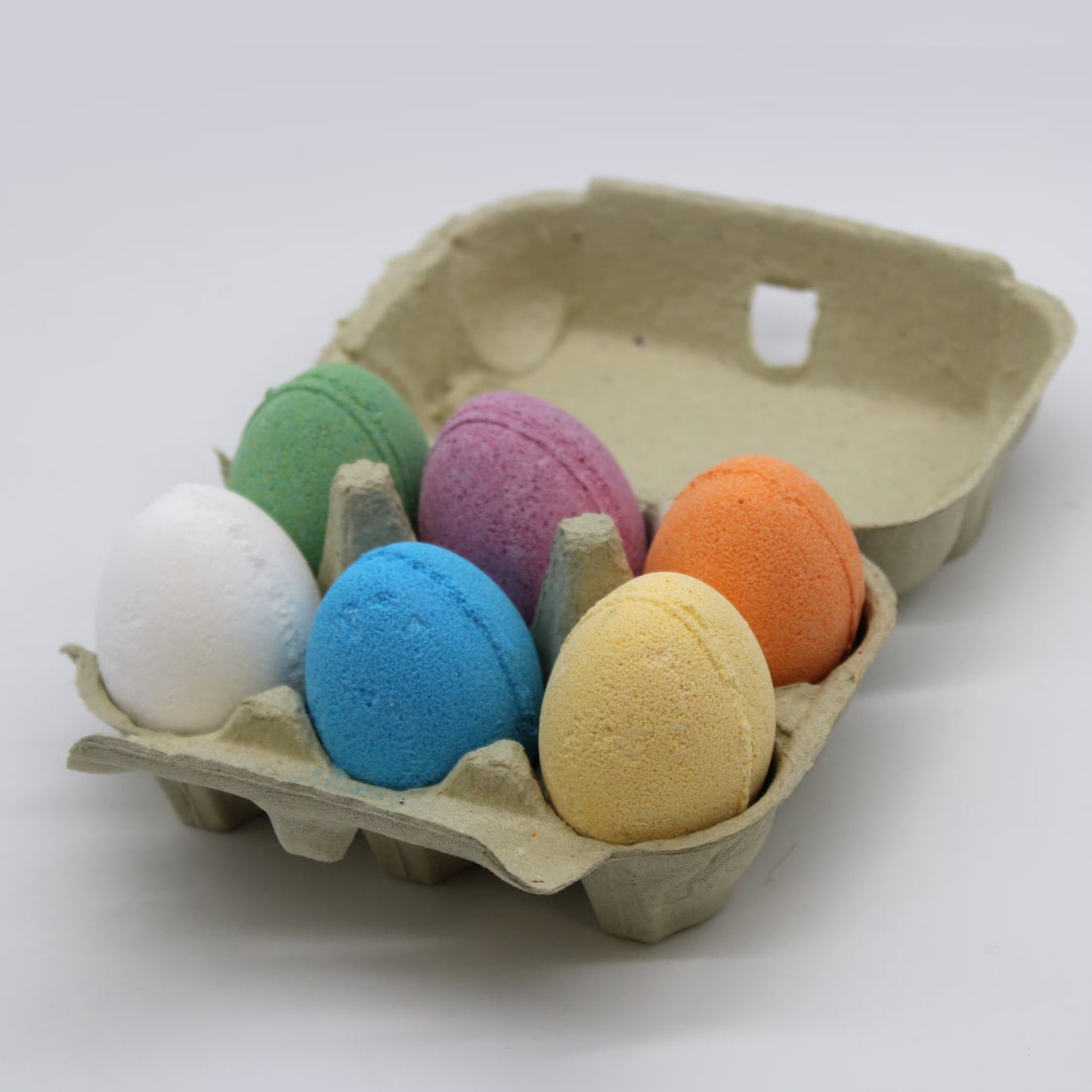 Egg shaped bath bombs in six fragrances presented in an egg carton.