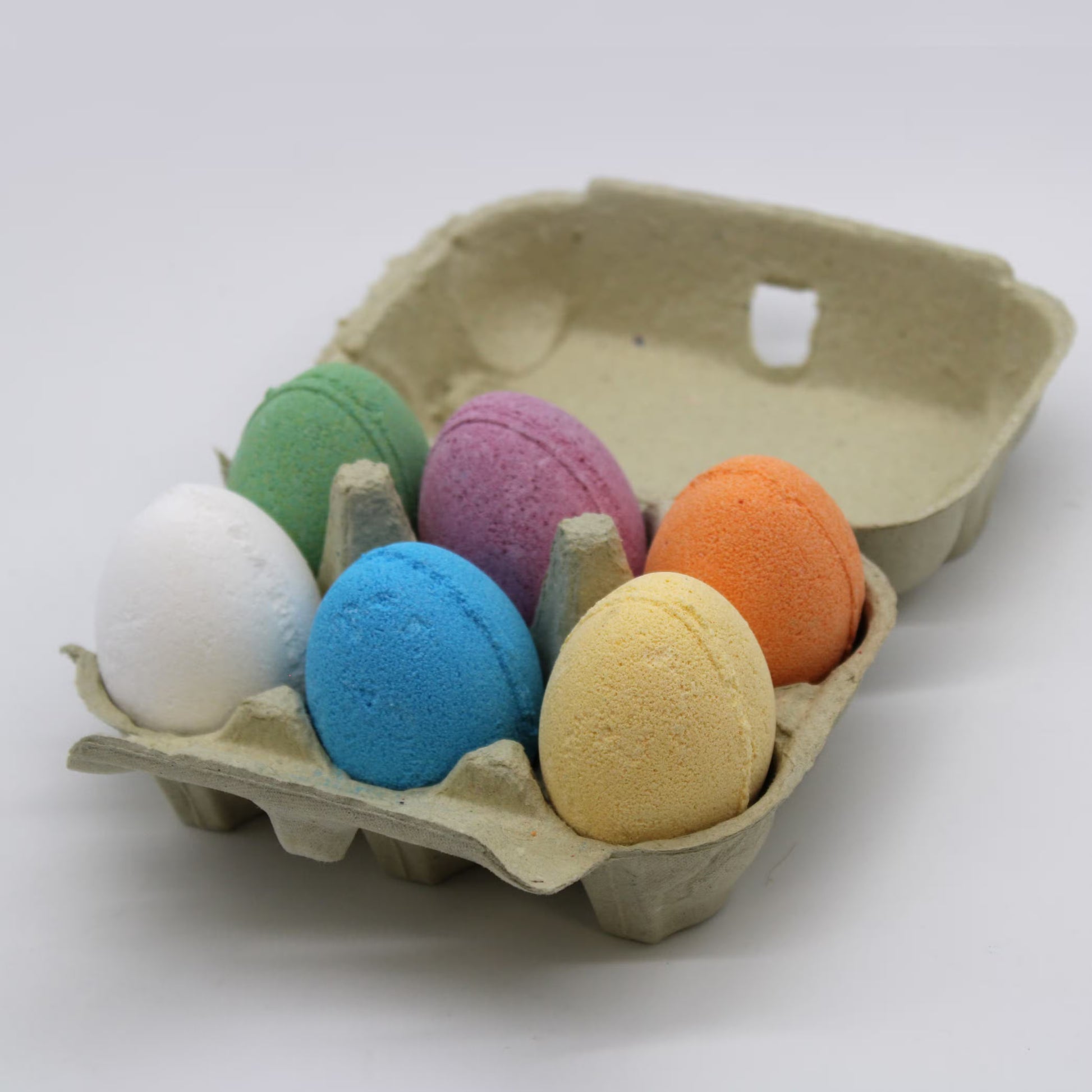 Egg shaped bath bombs in six fragrances presented in an egg carton.