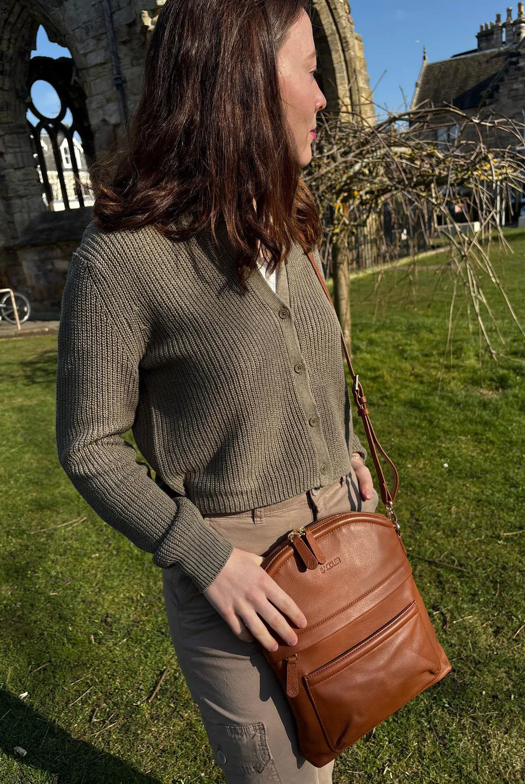 Tan leather crossbody bag worn by woman outdoors — Kimberley handcrafted leather bag