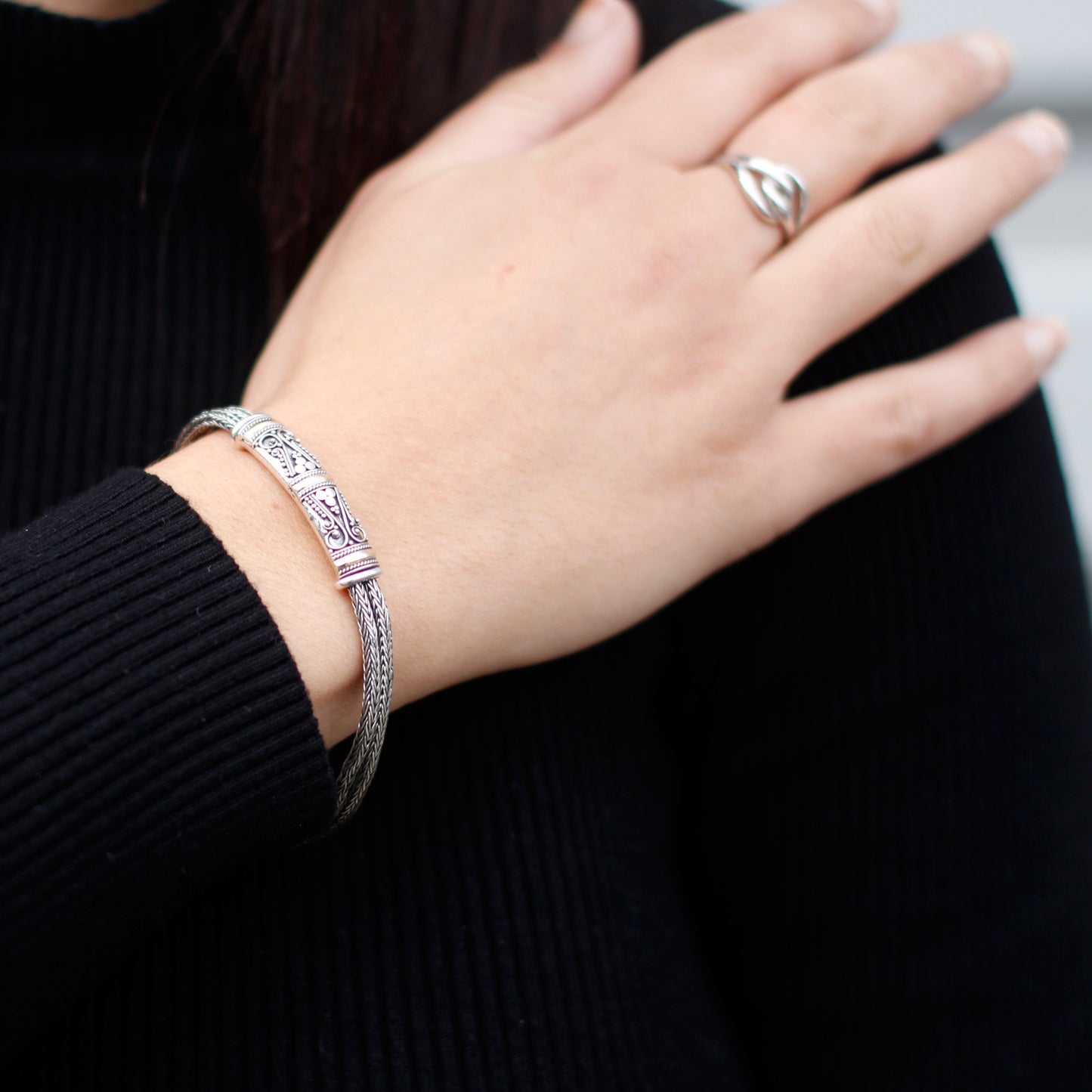 A bracelet made from Sterling silver and 18K gold on a woman's wrist. Has two chains. Unisex jewellery for men and women.