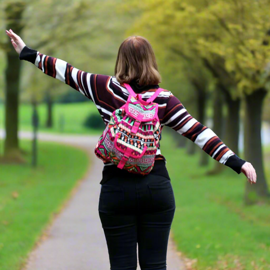 Woman with a multi-colour jaquard backpack walking in a park.